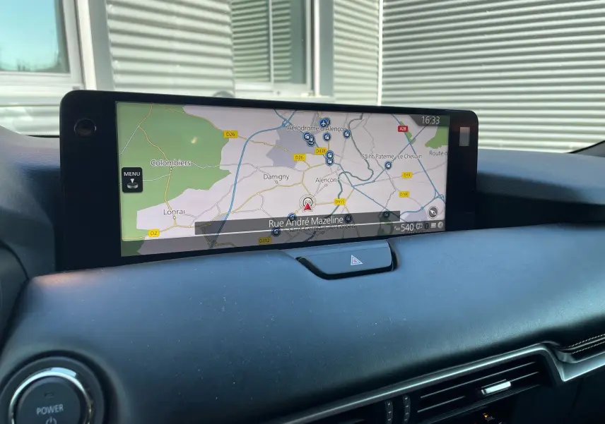 Écran tactile central affichant la navigation dans l'habitacle noir du Mazda CX-80 2024 hybride rechargeable.