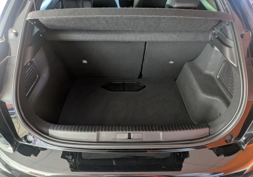 Coffre ouvert vu de l'arrière d'une DS3 noire 2024, montrant un espace de chargement propre et bien fini.