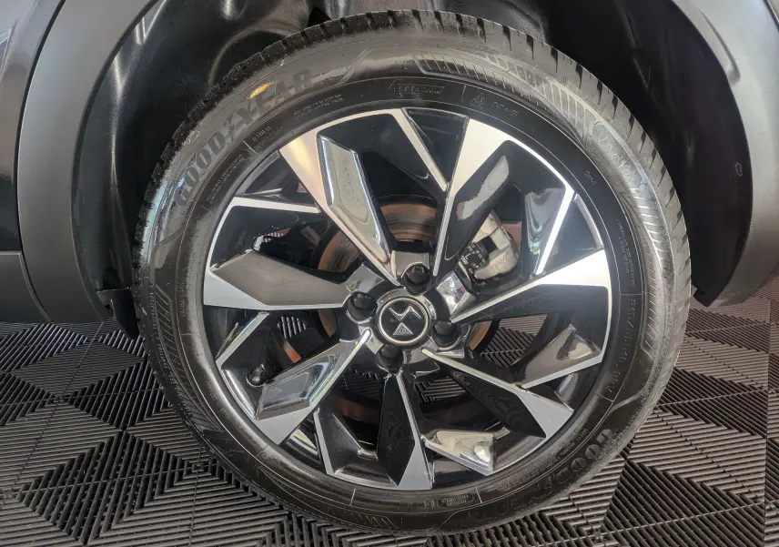 Gros plan sur la jante alliage bicolore 18 pouces d'une DS3 noire, mettant en valeur le logo DS central.