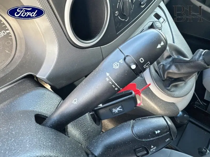 Gros plan sur la commande d’essuie-glace et levier de vitesses d’un Peugeot Partner Tepee blanc Banquise, intérieur gris.