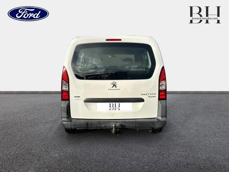 Vue arrière d'un Peugeot Partner Tepee blanc Banquise avec hayon et attelage visible sur fond neutre.