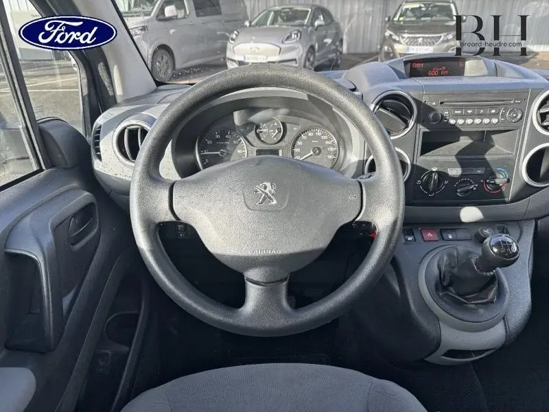 Vue intérieure centrée sur le volant Peugeot et tableau de bord avec levier de vitesse manuel, ambiance sobre et fonctionnelle.