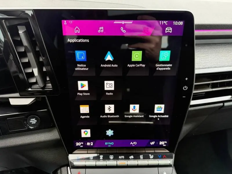 Écran tactile central du tableau de bord du Renault Austral 2025, affichant les applications connectées, avec boutons de commande autour.