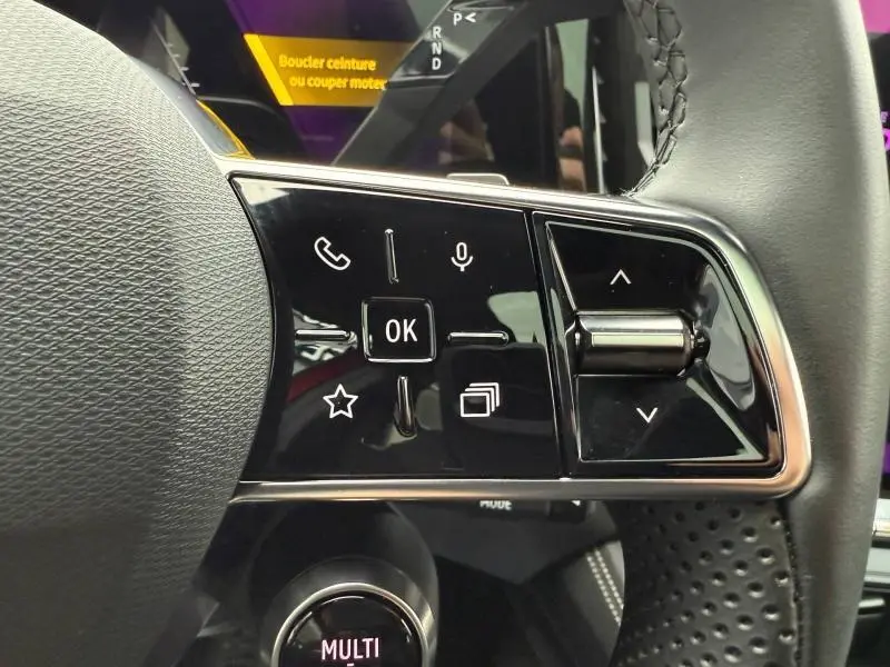 Gros plan sur les commandes au volant côté droit du Renault Austral 2025 en Rouge Flamme, boutons tactiles et molette.