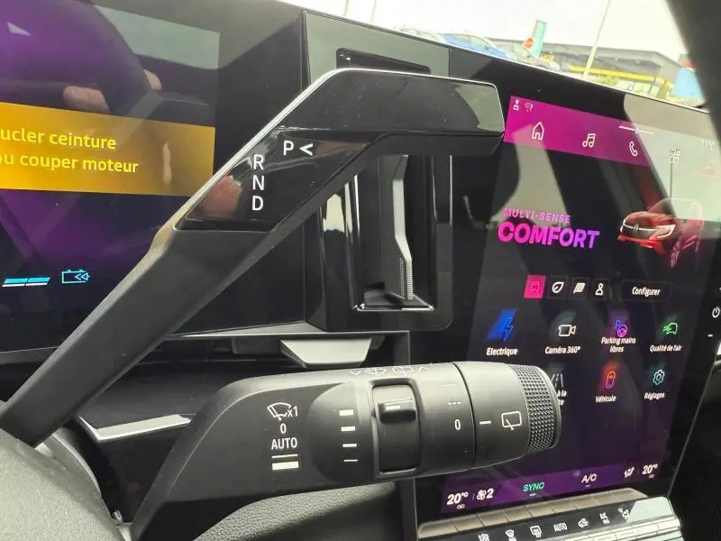 Gros plan sur la console centrale et levier de vitesses du Renault Austral Rouge Flamme, avec écran tactile affichant le mode Confort.