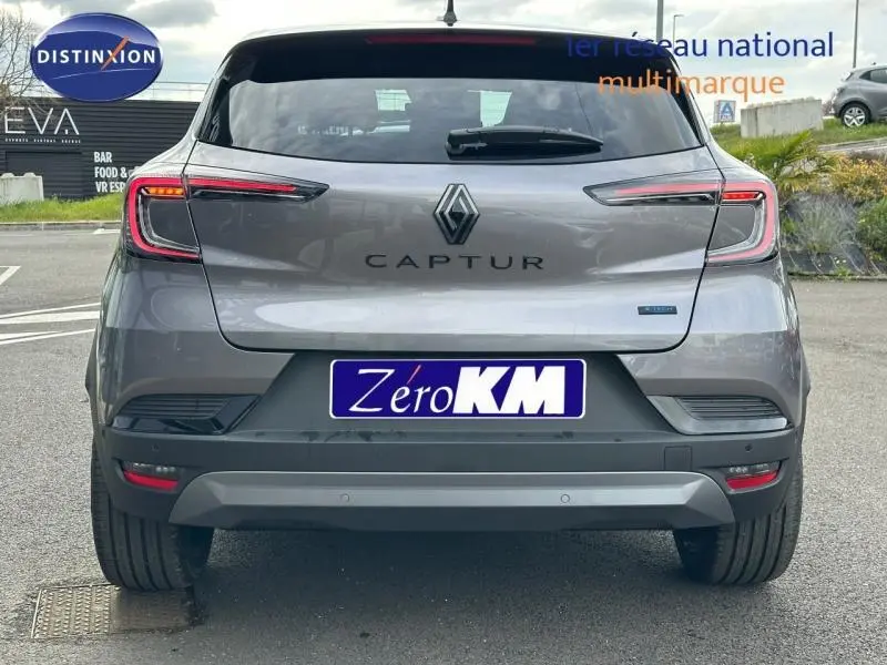 Vue arrière d’un Renault Captur 2026 gris Cassiopée avec toit noir, feux LED et badge hybride visible.
