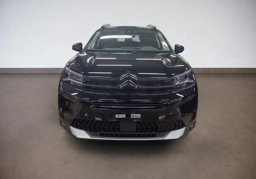 Vue avant d'un Citroën C5 Aircross Hybrid noir Perla avec calandre distinctive et hayon électrique visible.