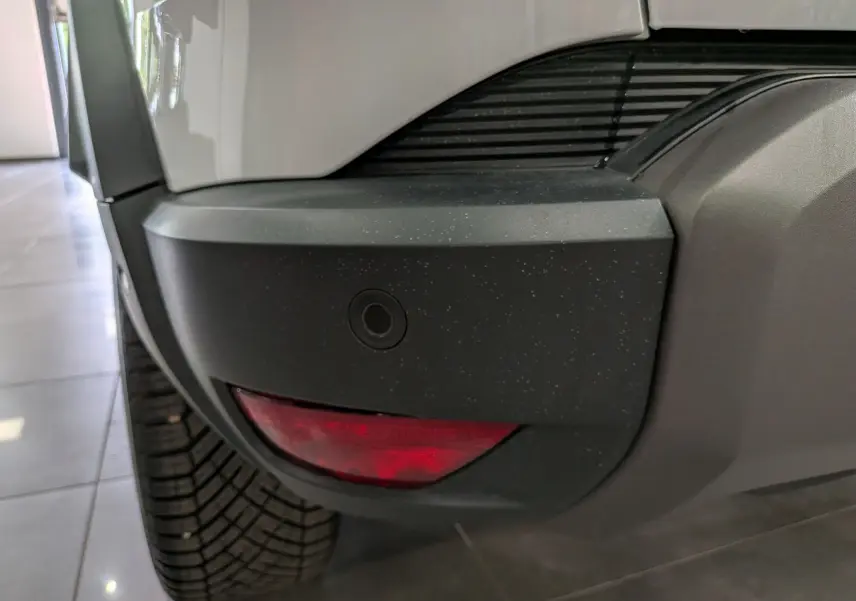 Gros plan sur le pare-chocs arrière droit noir et blanc glacier du Dacia Duster Hybrid-G 150 CH 4x4 JOURNEY 2026.