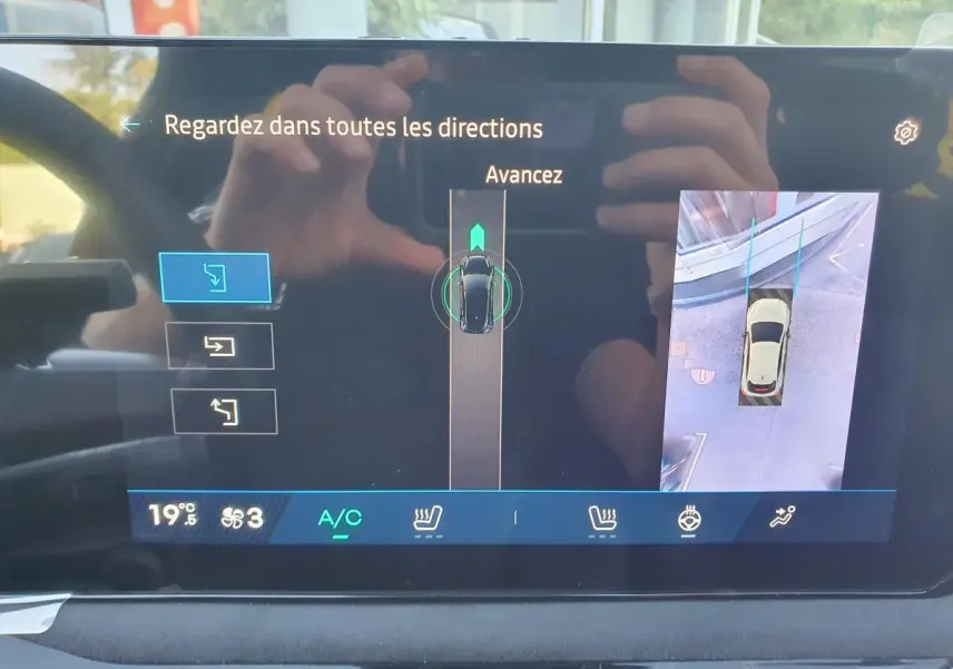 Écran tactile intérieur montrant la caméra de recul et l’aide au stationnement de la Renault Clio VI rouge Absolu.