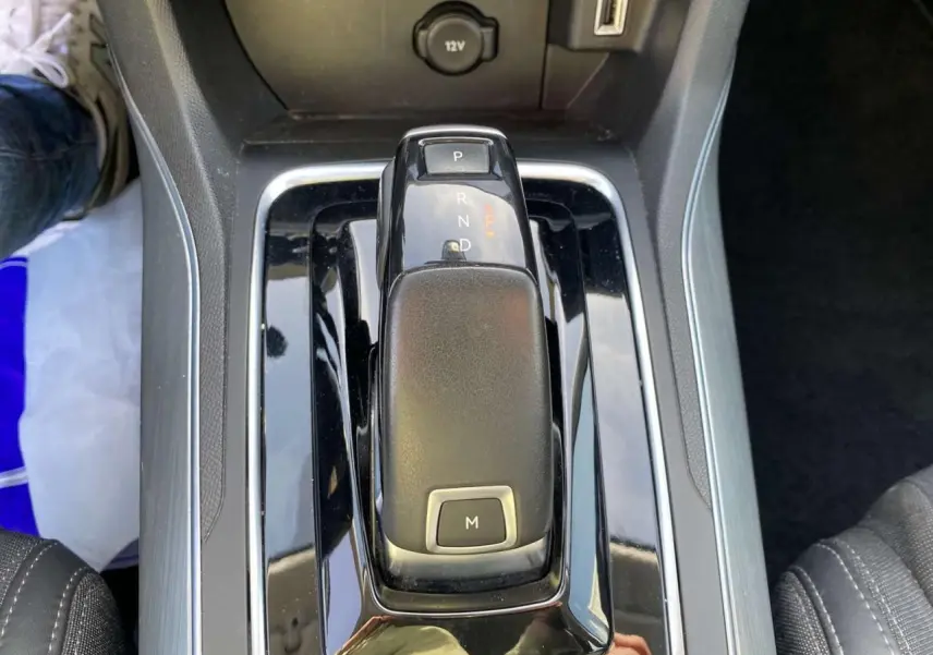Le levier de vitesses automatique noir brillant de la Peugeot 308 SW 2019 vu de dessus entre les sièges avant.