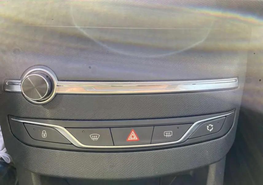 Gros plan sur la console centrale du Peugeot 308 SW gris Artense, montrant les boutons de verrouillage et d'alerte.