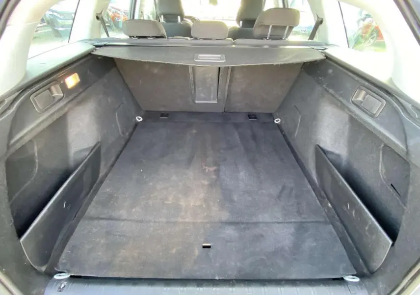 Coffre ouvert de la Peugeot 308 SW gris Artense, vue de l'arrière montrant l'espace de chargement et la banquette rabattue.