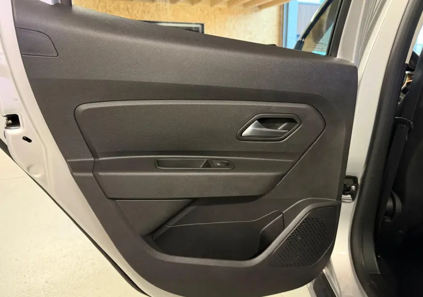 Porte arrière côté gauche du Dacia Duster gris 2019, avec panneau intérieur noir et commande de vitre électrique.