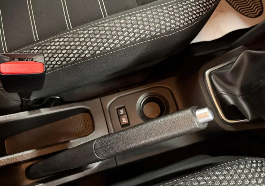 Vue rapprochée du frein à main et levier de vitesse manuel dans l'habitacle tissu noir du Dacia Duster gris 2019.