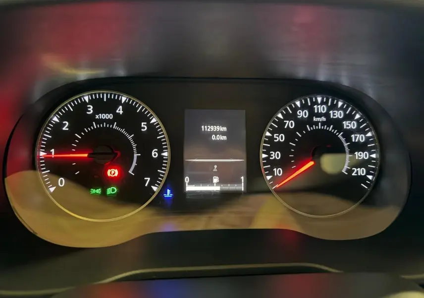 Gros plan sur le tableau de bord du Dacia Duster gris, affichant le compteur de vitesse et le compte-tours allumés.