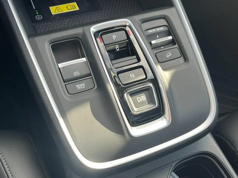 Gros plan sur la console centrale du Honda CR-V 2024 avec commandes de boîte auto et mode de conduite, finition noire.