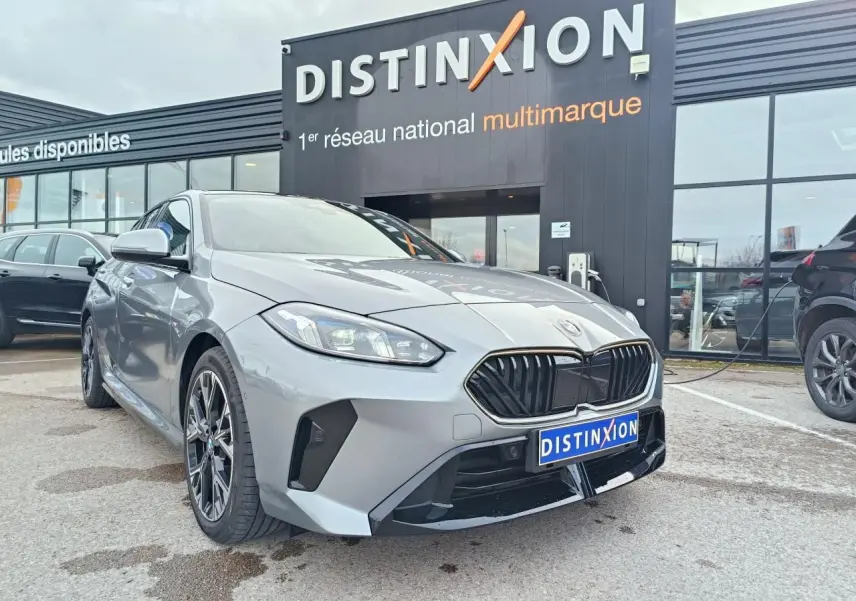 BMW Série 1 gris Skyscraper avec toit noir, vue 3/4 avant mettant en valeur la calandre M Sport et les jantes 18 pouces.