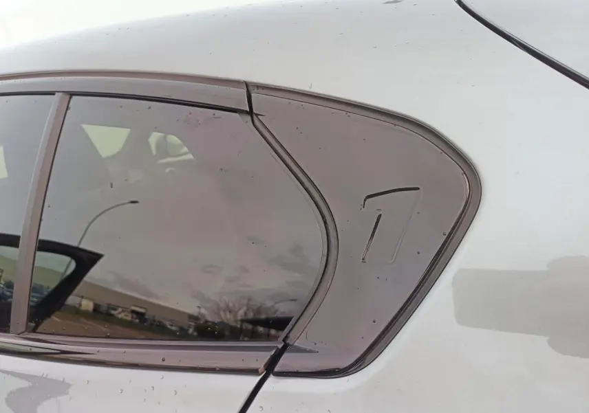 Détail de la vitre arrière droite fumée sur BMW Série 1 gris Skyscraper avec toit noir.