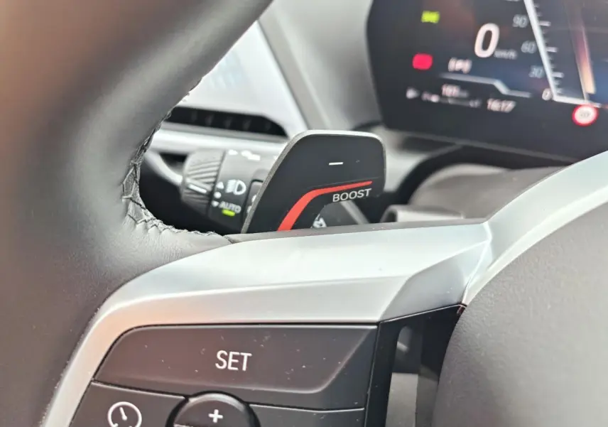 Gros plan sur la palette "BOOST" et les commandes au volant de la BMW Série 1 F70 gris Skyscraper, intérieur moderne.