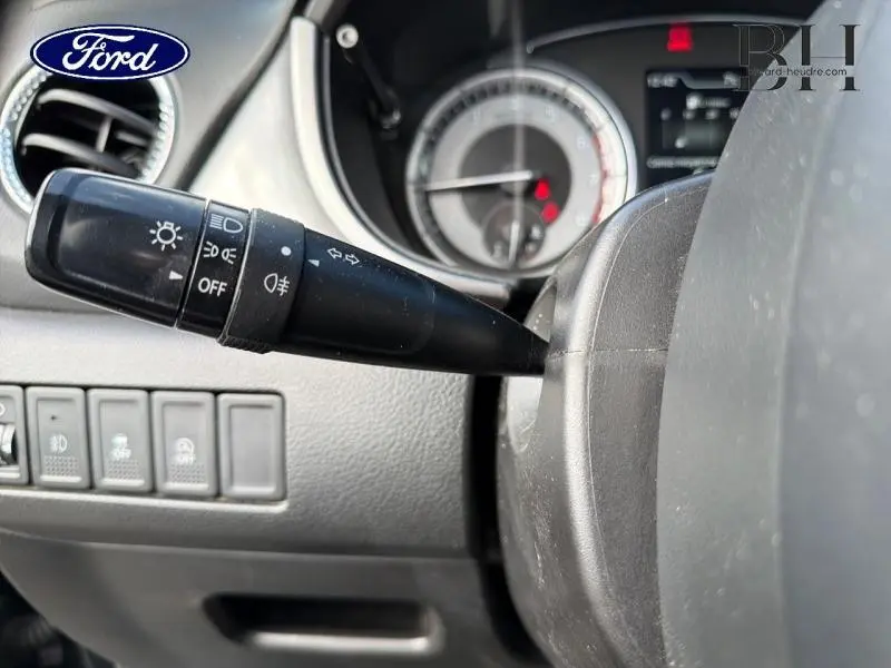 Gros plan sur la manette des phares et clignotants côté gauche du tableau de bord d’un Suzuki Vitara Cosmic Black Pearl.