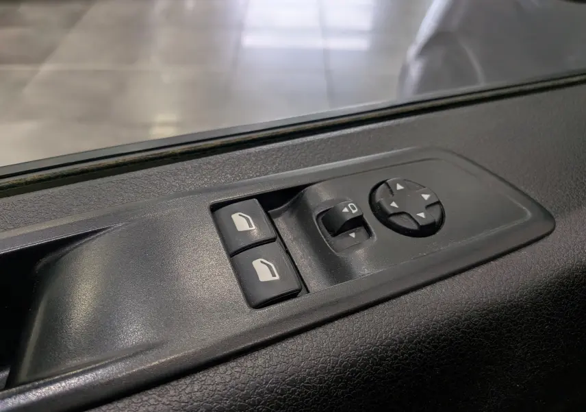 Gros plan sur les commandes de réglage des rétroviseurs et vitres côté conducteur du Peugeot Expert Fourgon gris acier.