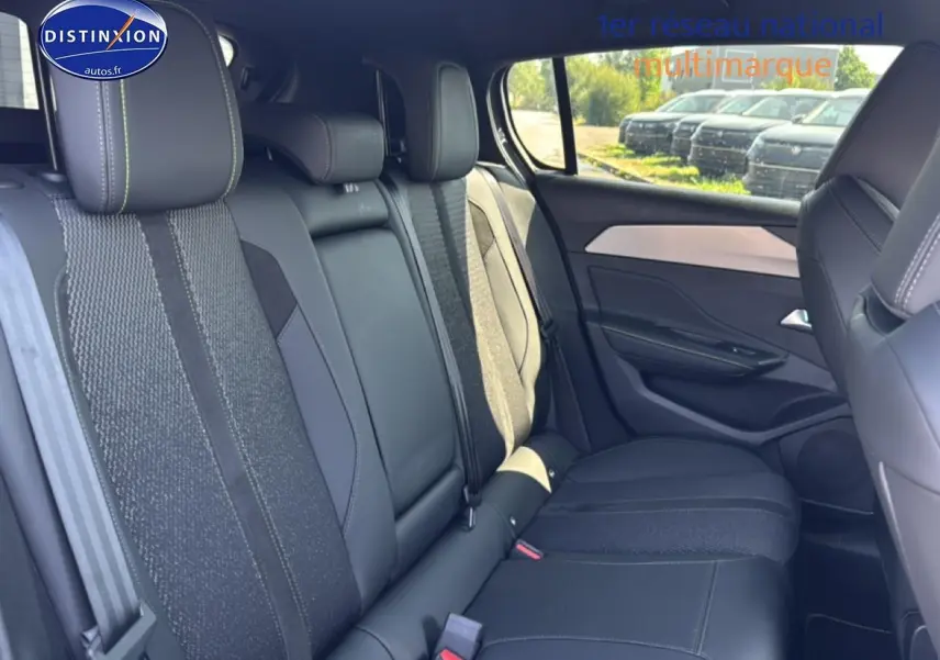 Vue latérale droite de l'intérieur arrière gris foncé de la Peugeot 308 1.2 hybrid 145 GT e-DCS6 avec sièges en tissu et cuir.