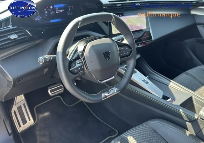 Vue intérieure côté conducteur du Peugeot 308 gris 2025, avec volant multifonction et écran tactile central.