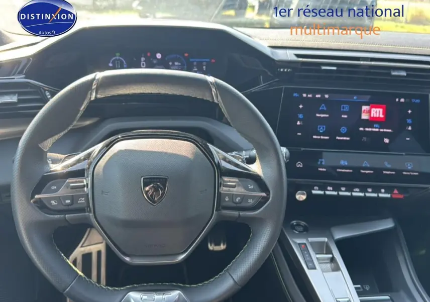 Vue intérieure centrée sur le volant cuir noir GT et l'écran tactile du tableau de bord d'une Peugeot 308 gris 2025.