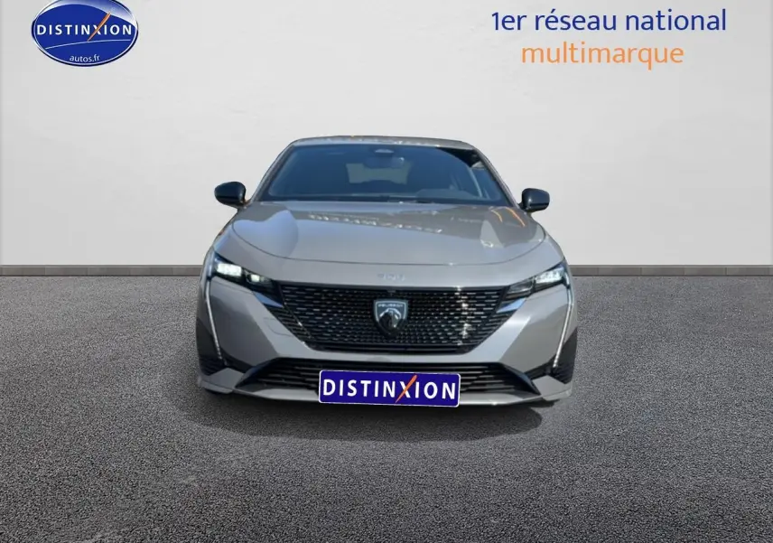 Vue avant frontale d'une Peugeot 308 gris métallisé avec calandre noire et phares LED allumés.