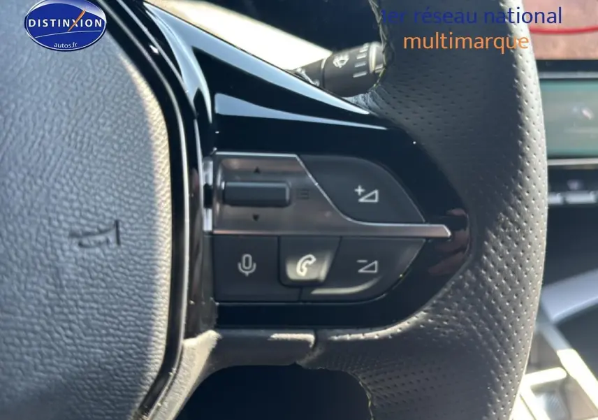 Gros plan sur les commandes vocales et téléphone du volant perforé noir d'une Peugeot 308 gris 1.2 hybrid 145 GT e-DCS6 2025.