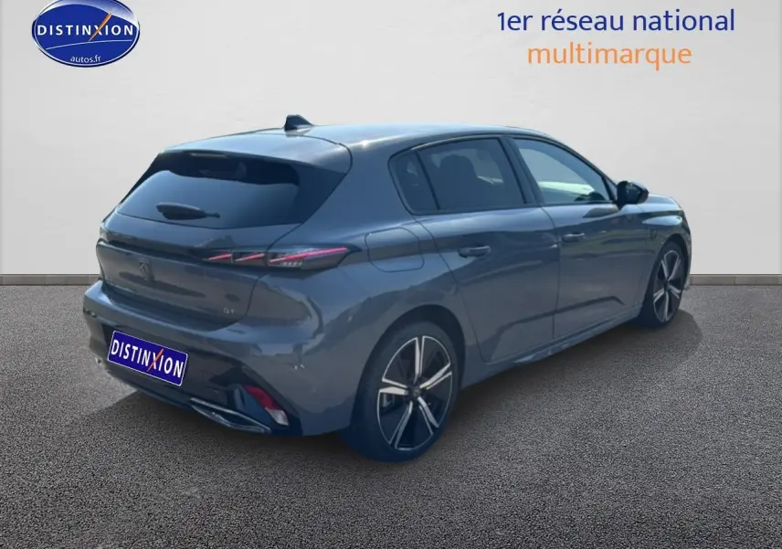 Vue 3/4 arrière droite d'une Peugeot 308 gris métallisé avec jantes alu et vitres arrière surteintées.