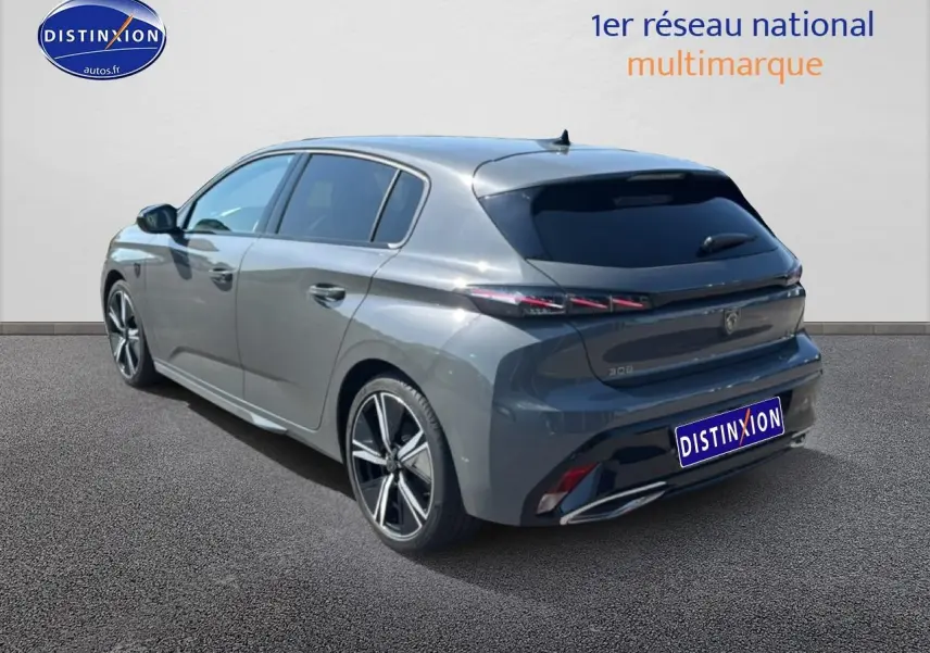 Peugeot 308 gris métallisé vue 3/4 arrière droit, jantes alliage et feux arrière LED distinctifs.