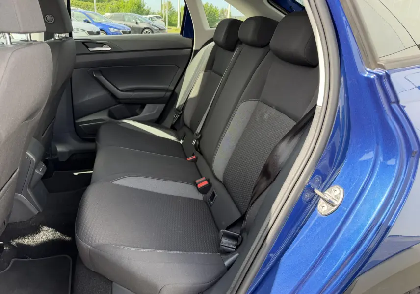 Vue côté droit de la banquette arrière noire du Volkswagen Taigo bleu avec porte ouverte en extérieur.