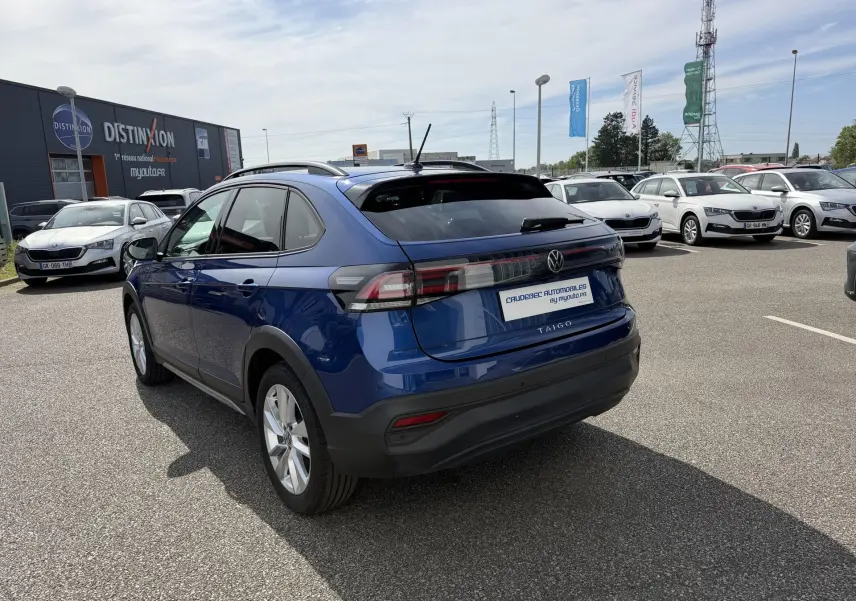 Volkswagen Taigo bleu métallisé vu en 3/4 arrière droit, avec feux arrière LED et jantes alliage 17 pouces.