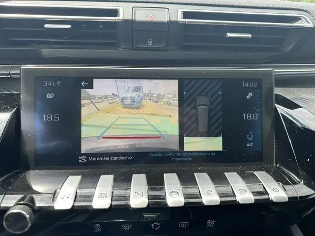 Écran central de la Peugeot 508 SW 2020 montrant la caméra de recul avec vue arrière et capteurs d’aide au stationnement.