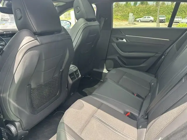 Vue intérieure arrière droite de la Peugeot 508 SW gris 2020, montrant les sièges en cuir noir et les détails de la porte.