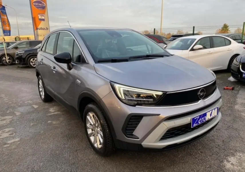Opel Crossland gris alu en 3/4 avant droit, avec coques de rétroviseurs noires et jantes alliage 16 pouces.