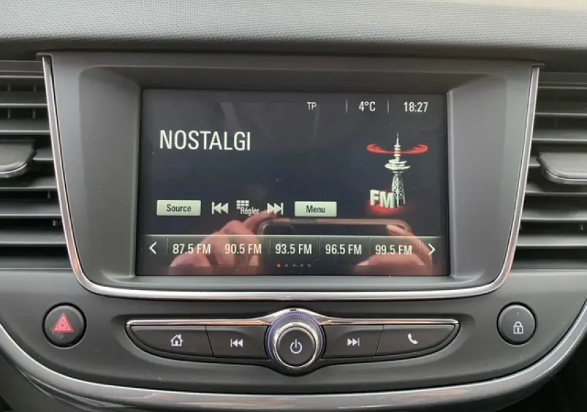 Écran central de l'Opel Crossland 2022 affichant la radio FM sur la station Nostalgie, entouré de commandes grises.