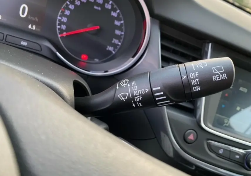 Gros plan sur la commande des essuie-glaces à gauche du volant dans l'habitacle de l'Opel Crossland gris alu 2022.