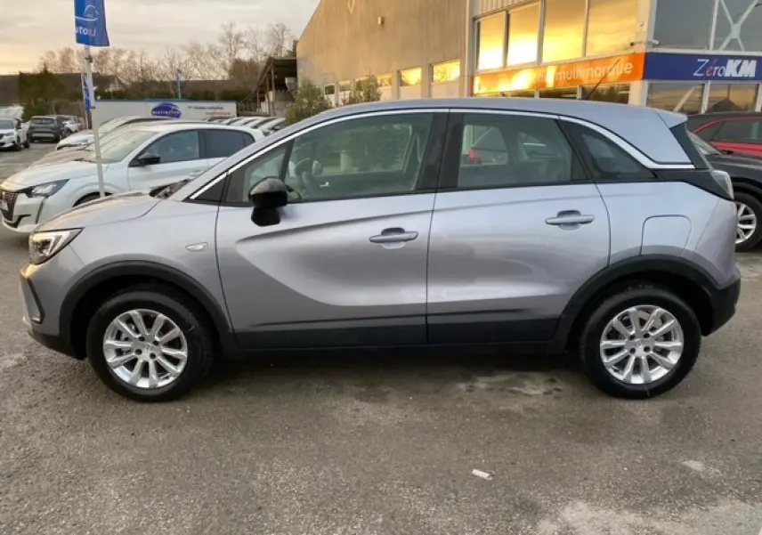 Opel Crossland gris alu vu de profil côté gauche, avec coques de rétroviseurs noires et jantes alliage 16 pouces.
