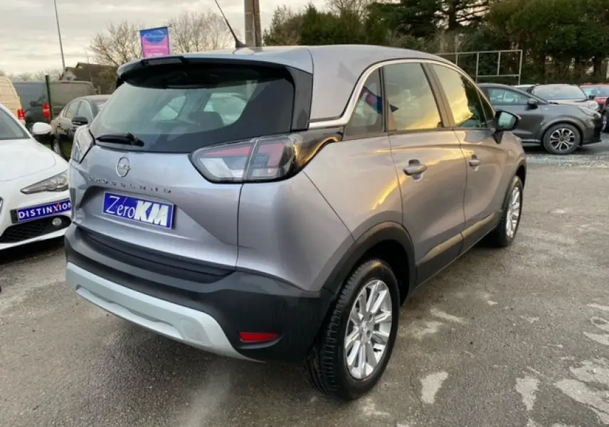 Opel Crossland gris alu vu en 3/4 arrière droit avec toit couleur carrosserie et jantes alliage 16 pouces.