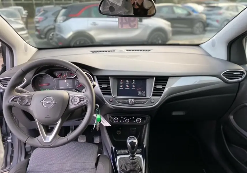 Vue intérieure de l'Opel Crossland gris alu 2022, tableau de bord moderne avec écran tactile et volant multifonction.