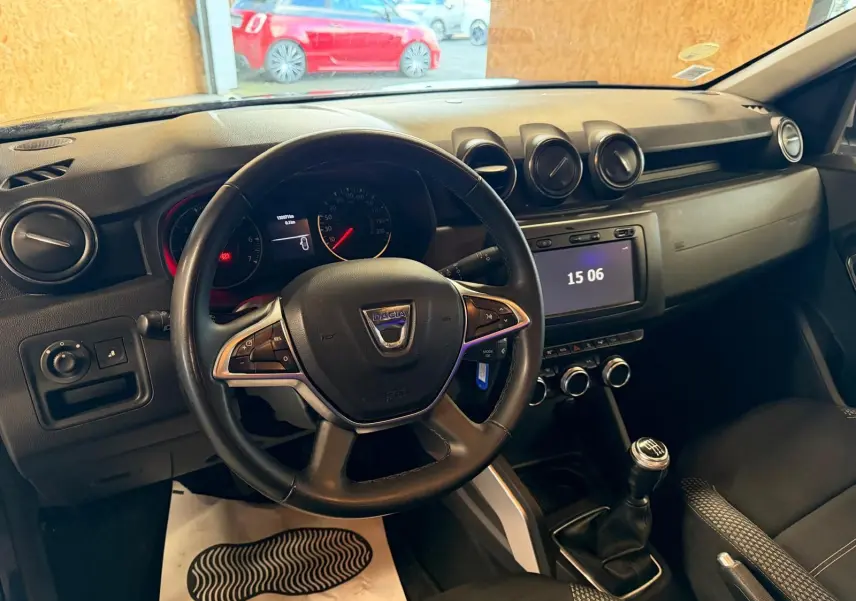 Vue intérieure du tableau de bord et volant noir du Dacia Duster 1.5 BlueDCI Prestige avec boîte manuelle.