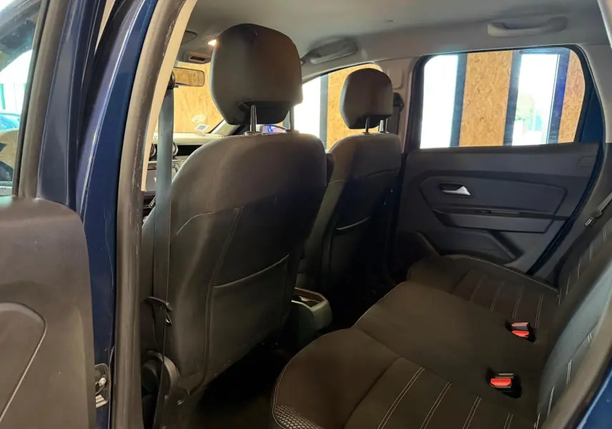 Vue intérieure arrière du Dacia Duster bleu, montrant les sièges tissu Prestige noirs et les appuie-têtes arrière.
