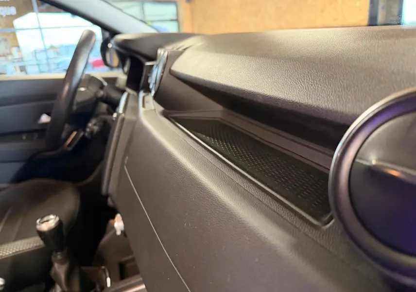 Intérieur du Dacia Duster Prestige, vue côté passager du tableau de bord et levier de vitesses manuel noir.