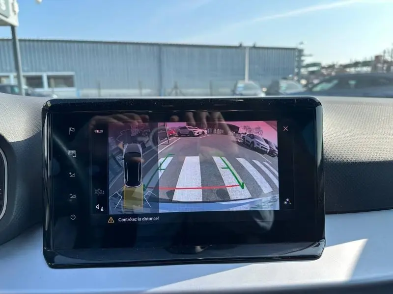 Vue intérieure de l’écran multimédia montrant la caméra de recul du SEAT Arona blanc Candy avec toit noir Minuit.