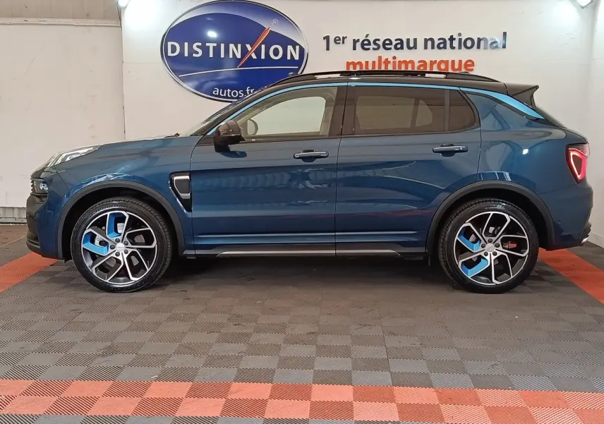 Vue de profil côté gauche d'un SUV Link & Co 01 hybride rechargeable bleu avec jantes noires et bleues, toit noir et feux arrière triangulaires.