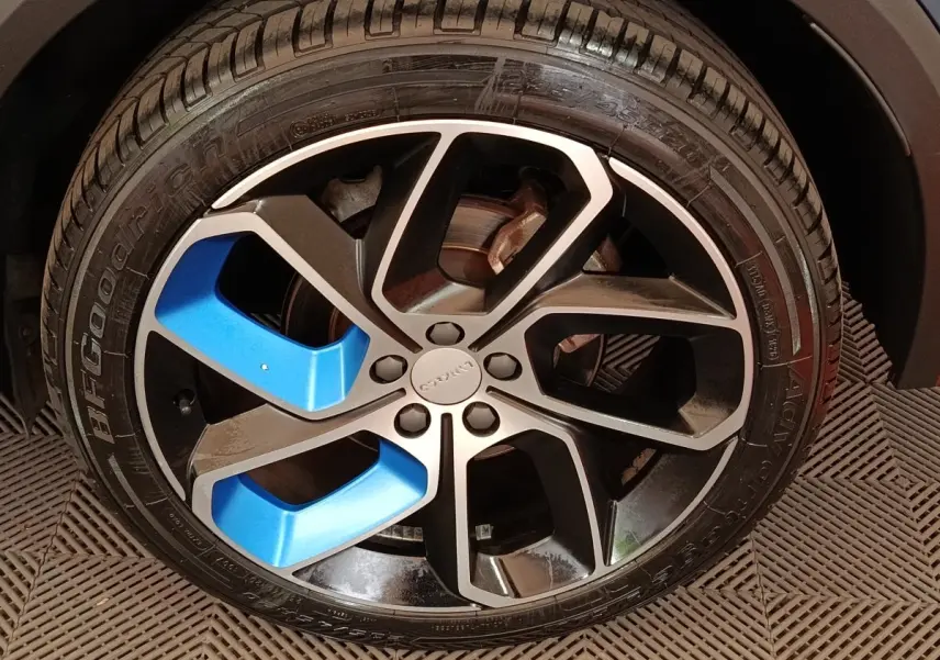Gros plan sur la jante avant noire et bleu du SUV LINK & CO 01 hybride rechargeable 2023.