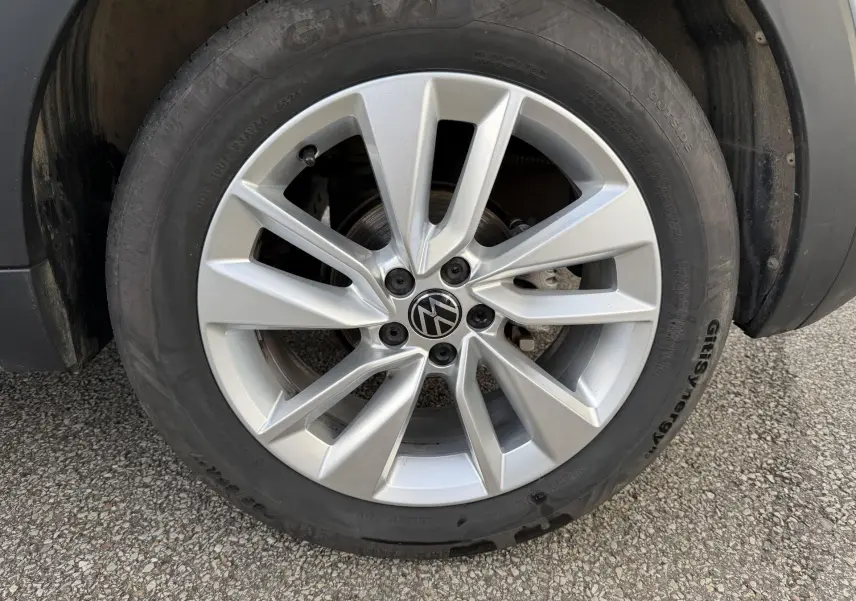 Gros plan sur la jante alliage 17 pouces grise du Volkswagen T-Cross 2025 avec pneu Giti sur sol bitumé.