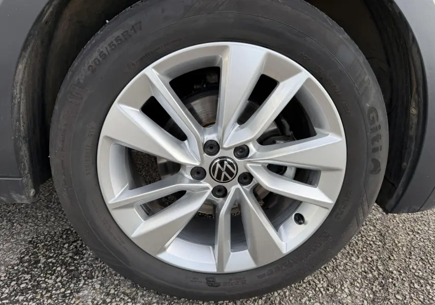 Gros plan sur la jante alliage 17 pouces Bangalore argentée du Volkswagen T-Cross gris, avec pneu 205/55 R17 visible.
